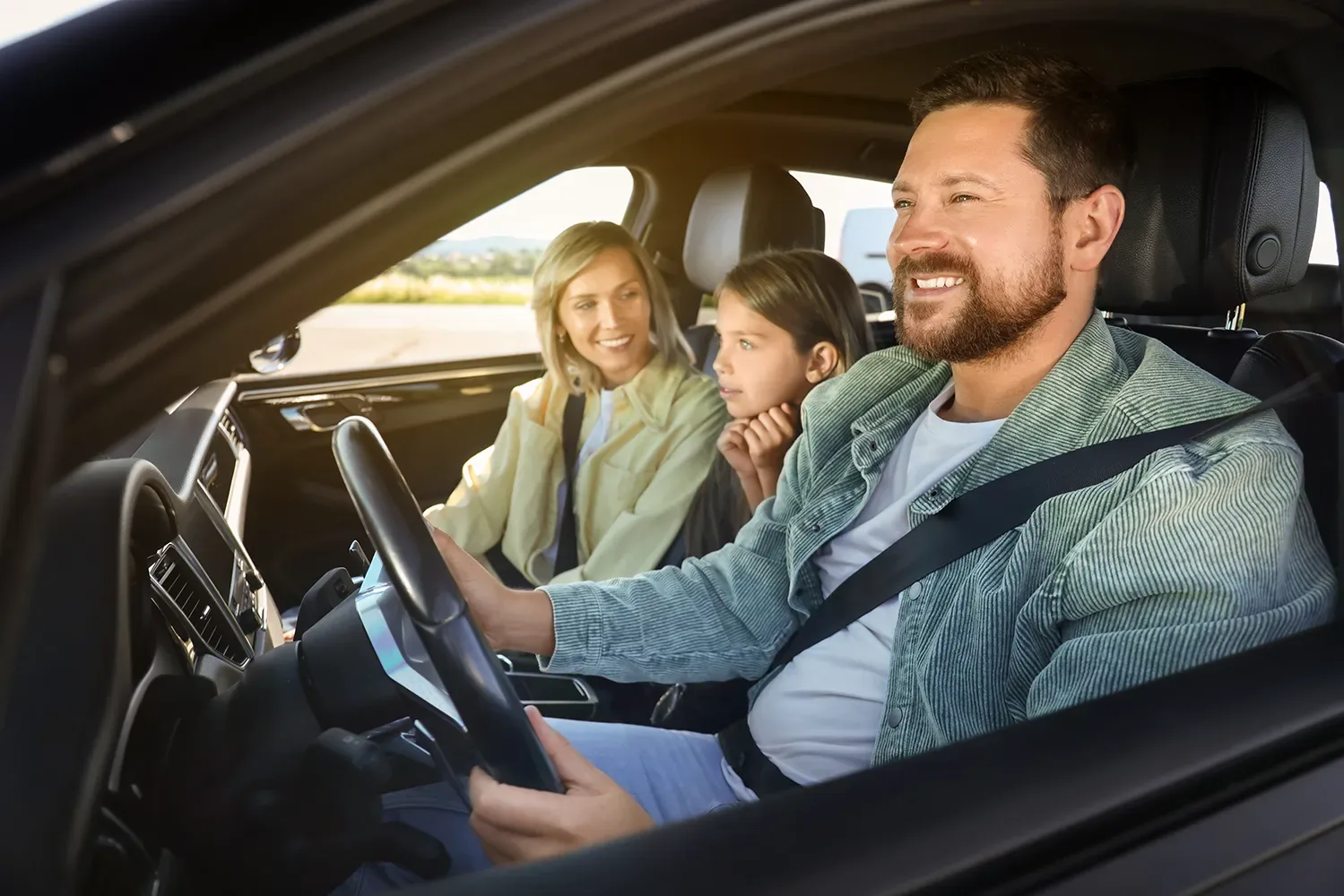 A family smiling inside their freshly washed car